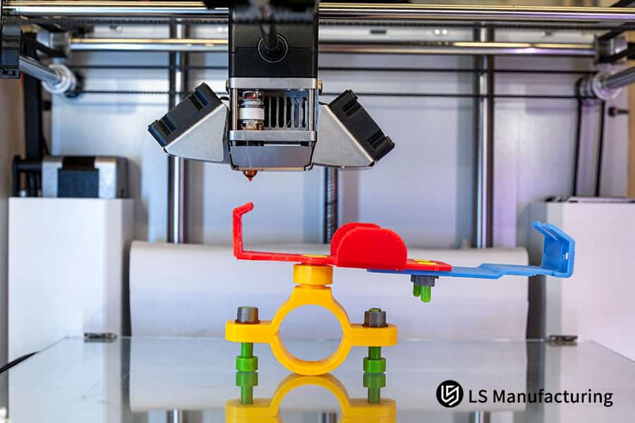 FDM方式の3Dプリンティングサービスは、溶融したオレンジ色のPLAプラスチックフィラメントを押し出し、部品を層ごとに構築します。