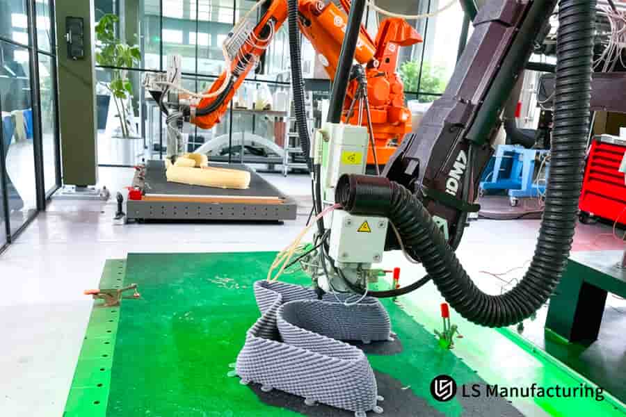 Robotic arm precisely deposits composite material onto mold in industrial manufacturing lab.