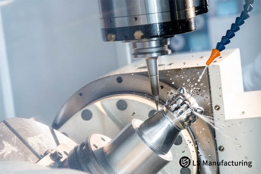 5-axis CNC machining mills stainless steel ball end with coolant spray.