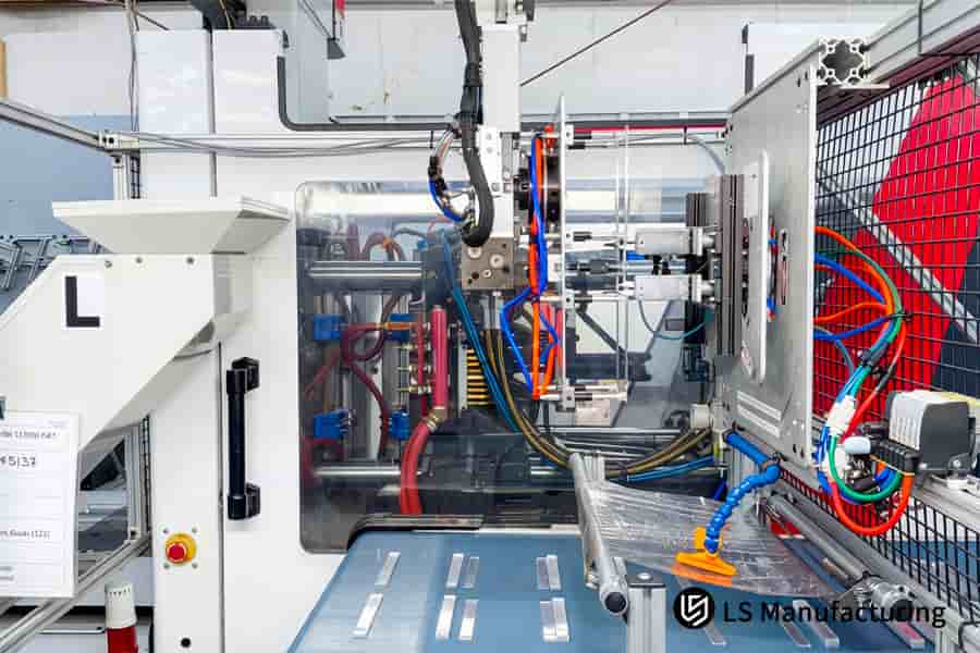 Robotic gripper transports clear plastic containers along automated conveyor systems in production facility.