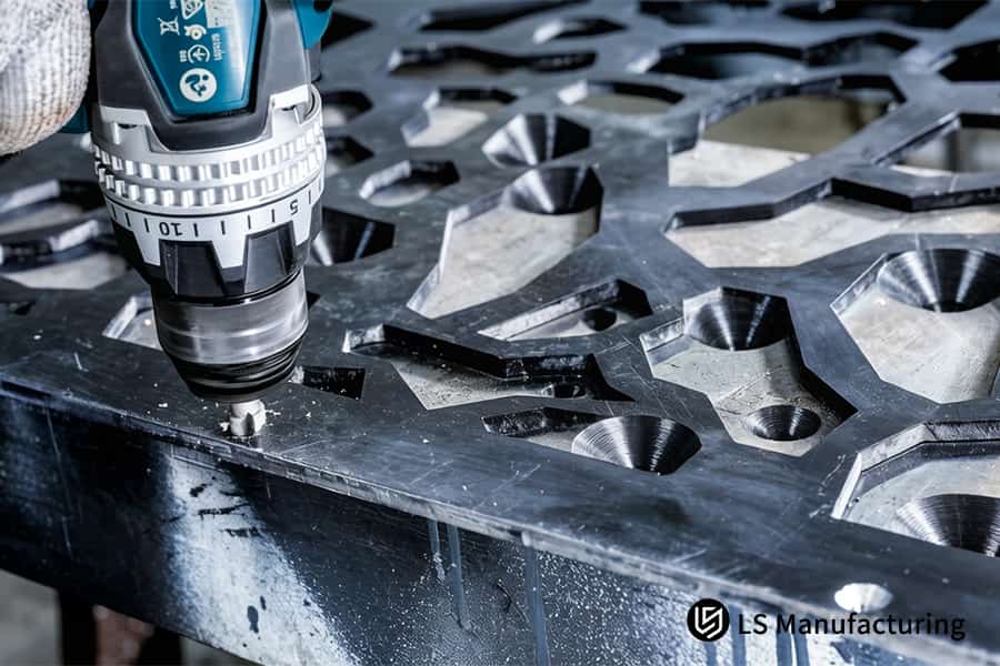 CNC machining drills holes into carbon steel plates for custom perforated sheet metal facades.