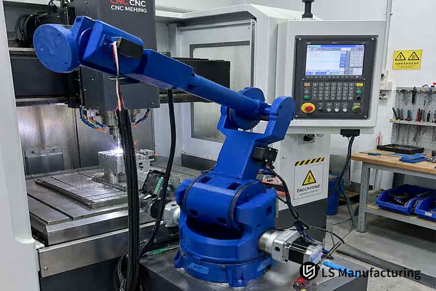 Un bras robotisé industriel travaille à côté d'un centre d'usinage CNC sur un étage de cellule automatisée.