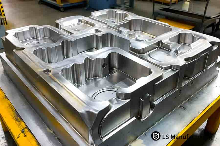 A precision large mold tooling block with milled cavities sits ready for high-volume injection molding production.