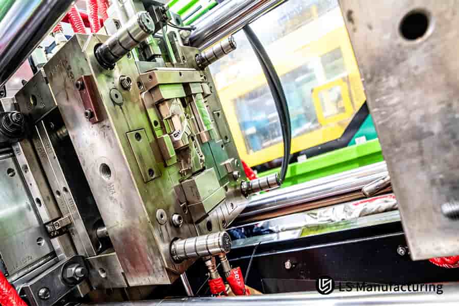 Technicians adjust a custom precision mold tooling to prevent part sticking in automotive production.