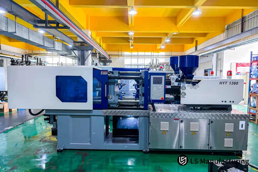 La macchina per lo stampaggio a iniezione HYT 1380 inietta materiale PEEK fuso in uno stampo ad alta precisione per parti aerospaziali.
