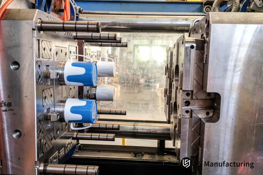 Injection molding produces blue and white plastic drink cups for food service industries.