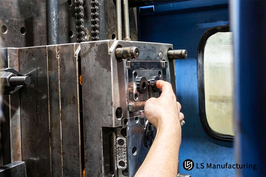 Un tecnico calibra 4140 bulloni per stampi in acciaio con un volantino per la prototipazione rapida dello stampaggio a iniezione.