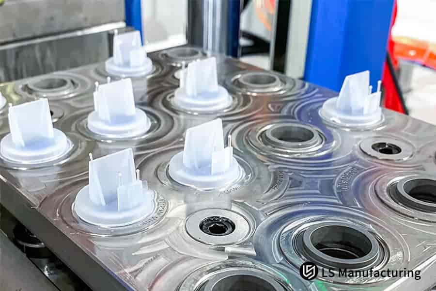 Heated nozzles inject neoprene at 150°C into steel cavities to form seals for automotive fluid lines.