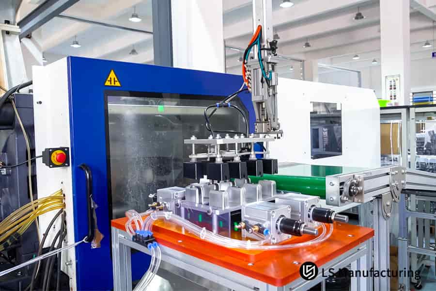 Les services de moulage par injection utilisent un bras robotisé pour produire des pièces en plastique dans un environnement d'usine automatisé.