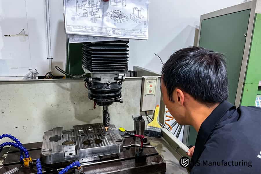 Um técnico opera um centro de usinagem utilizando um desenho técnico para a produção de moldes em baixo volume a preços acessíveis.