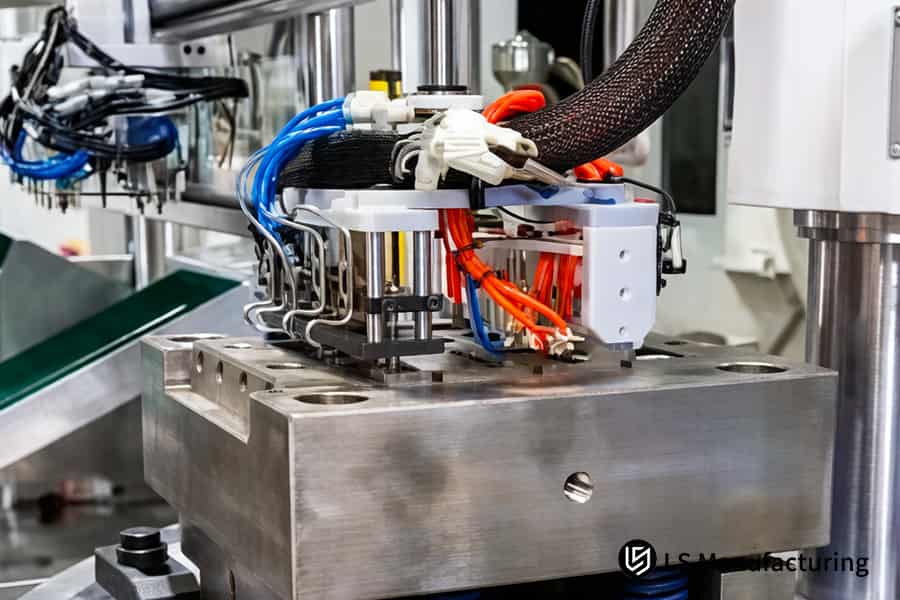 El moldeo por inserción de plástico sobre metal inyecta polímero PBT alrededor de un inserto eléctrico de latón para un conector industrial.