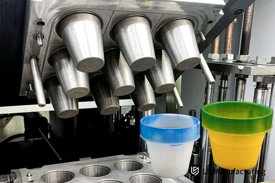 Metal molds positioned above colored silicone containers enable high-volume production of industrial parts.