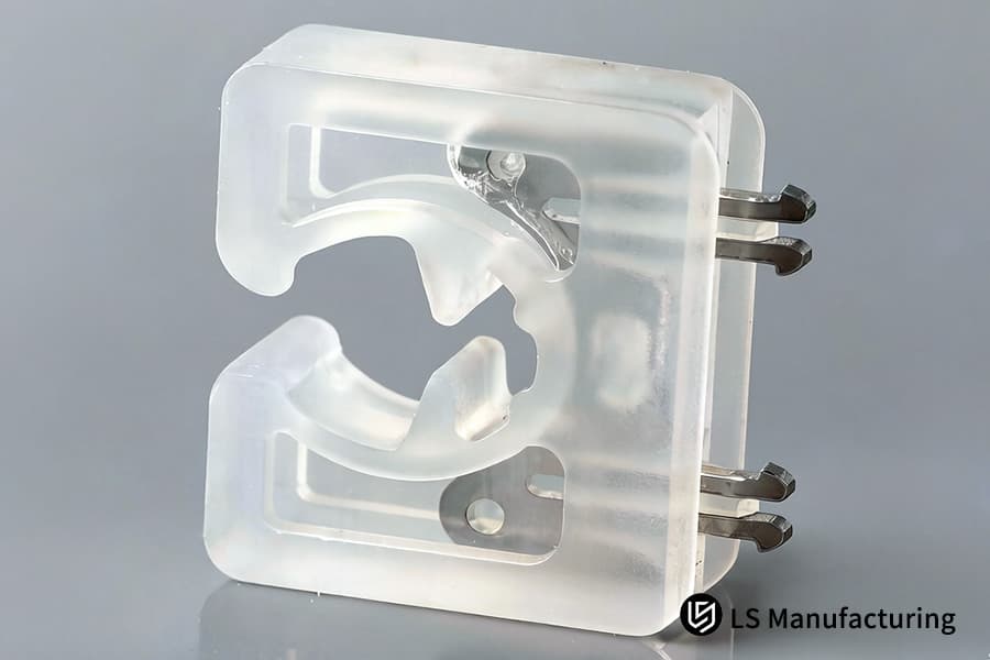 A clear silicone jig with embedded metal pins secures components for precision manufacturing applications.