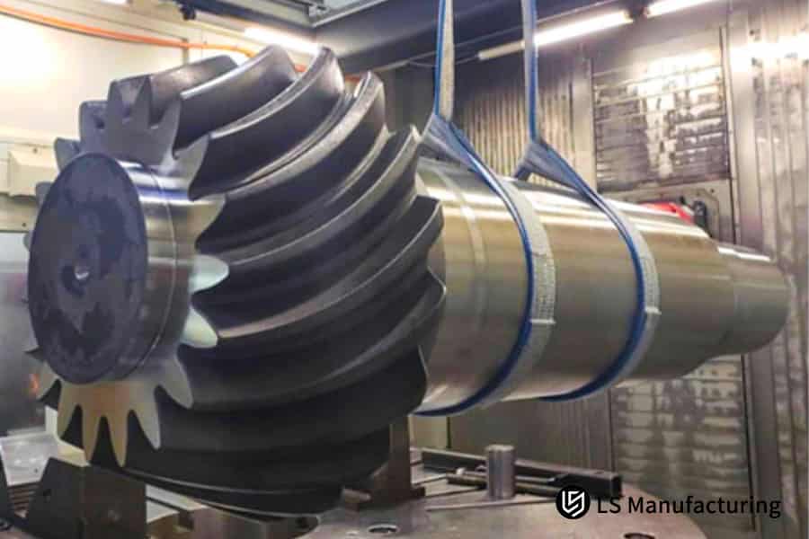 Engrenagem helicoidal grande suspensa por cintas azuis para içamento, fabricada pela LS Manufacturing.jpg