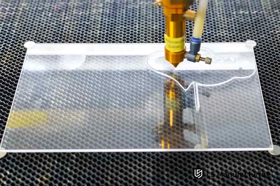 Laser cutting drills holes in clear acrylic for kitchen appliance control buttons.