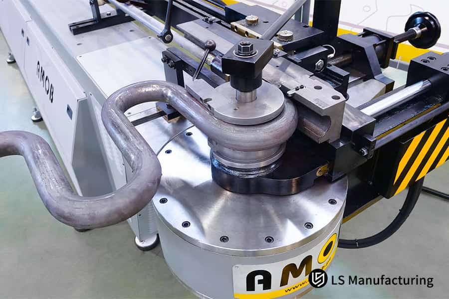 Una piegatrice CNC forma un tubo in acciaio inossidabile con un mandrino per parti di scarico automobilistiche di alta precisione.