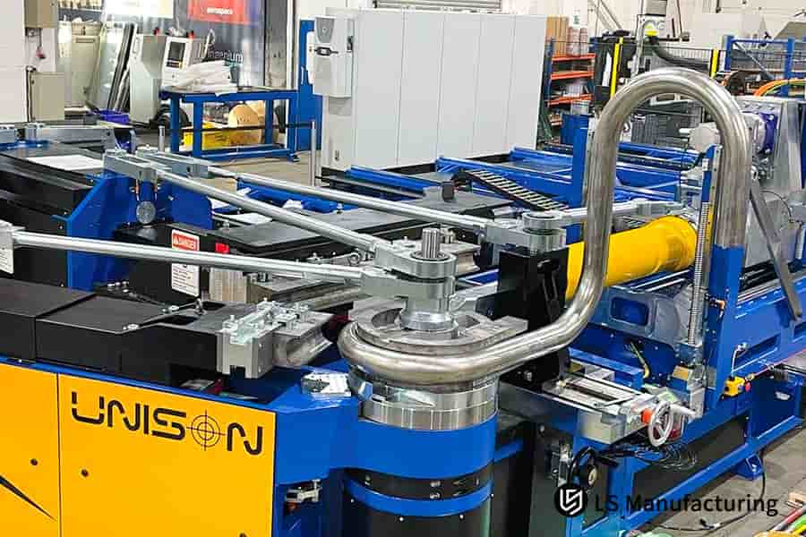 Piegatura di un tubo in acciaio inossidabile rivestito con una macchina CNC per parti di impianti idraulici o di fluidi industriali.