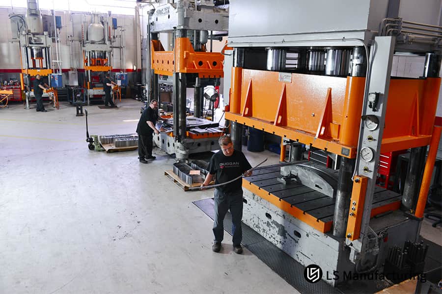 Formatura di una lunga staffa di connettore in acciaio laminato a freddo su una pressa idraulica per l'assemblaggio di automobili o macchinari.
