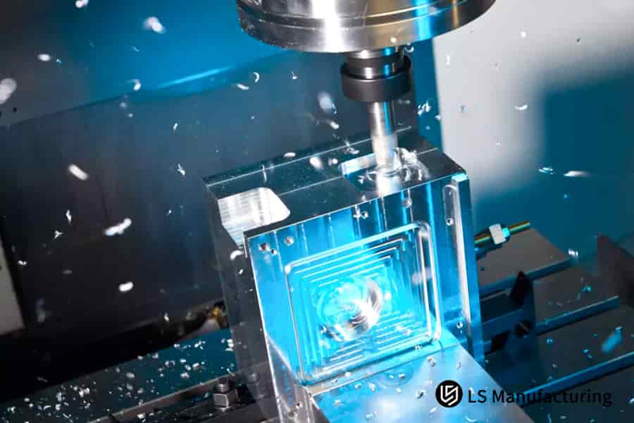 Milling tool cutting intricate channels in a clear blue block by LS Manufacturing.jpg