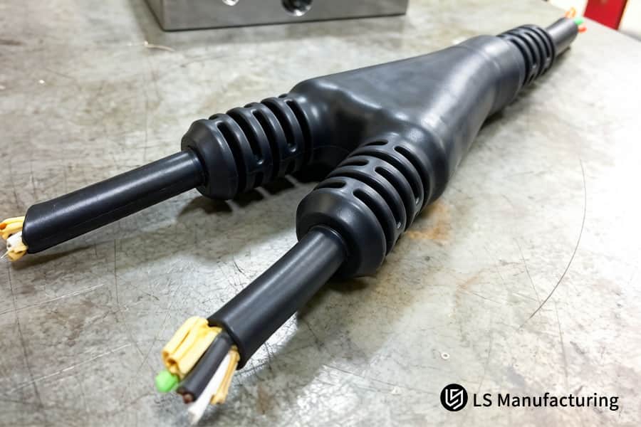 Due connettori per cavi sovrastampati in TPE nero sono pronti per essere assemblati nei sistemi di controllo dell'automazione industriale.
