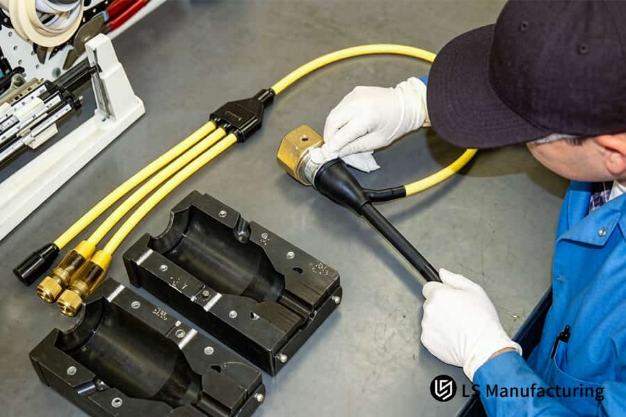 A technician inspects a connector component to ensure precision and quality in a precision overmolding manufacturer.
