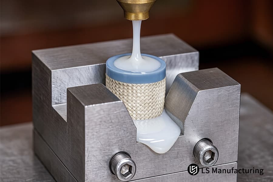 Il materiale plastico bianco fuso fuoriesce da un ugello nella cavità aperta di uno strumento metallico di precisione.