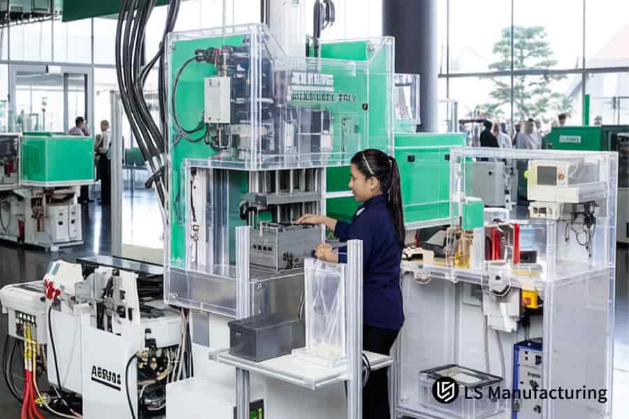 A technician monitors molten polypropylene injection into a car bumper mold under transparent safety guards.