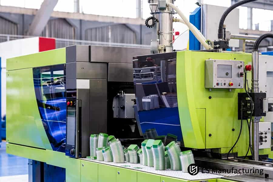 Injection molding machine produces green stackable cups using food grade polypropylene resin materials.