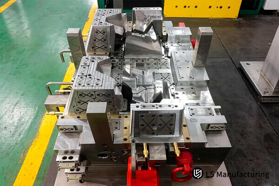 This large steel injection mold for OEM vehicle parts injection molding is positioned on the factory floor for assembly.
