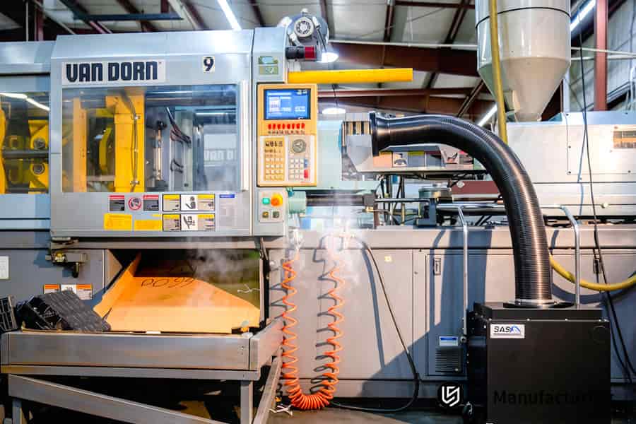 Precision large part molding creates an orange polymer ventilation duct on a VAN DORN press.