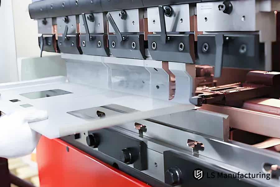 A worker adjusts a high-precision bending press.