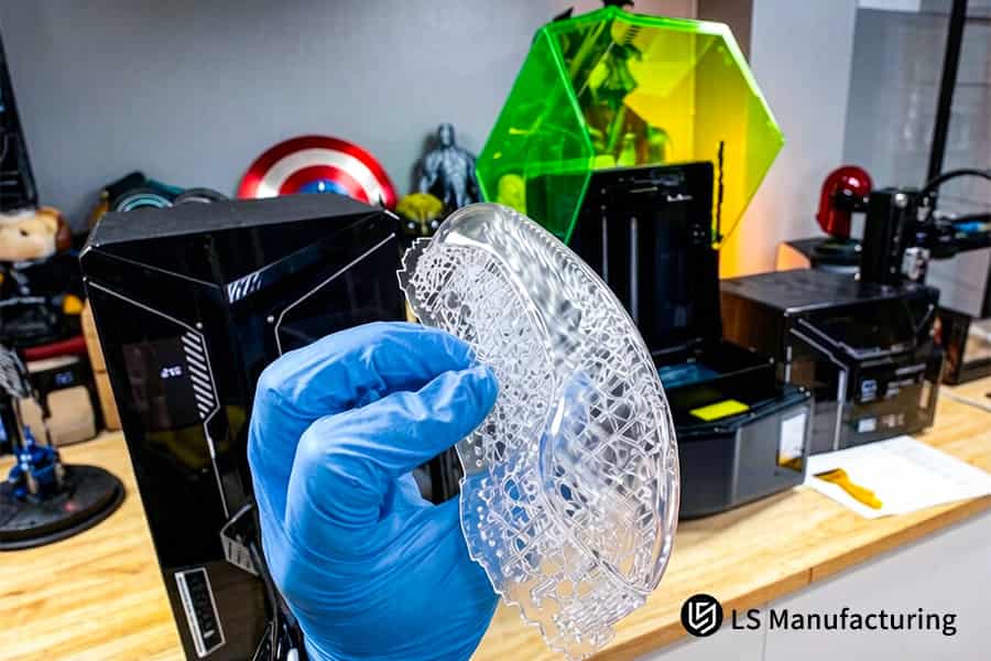 Scraper removes clear resin sculpture from platform for post processing in workshop.