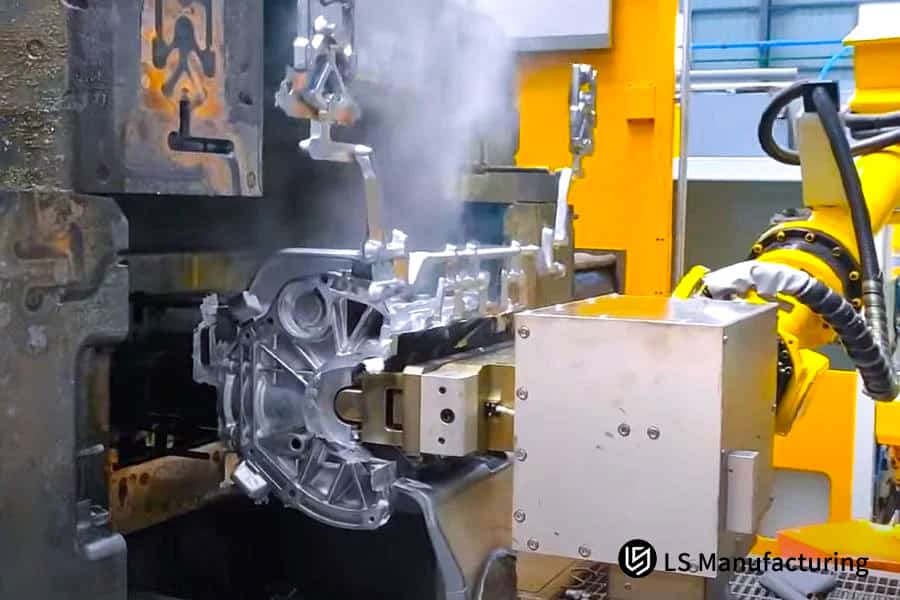 A robot arm positions a cast metal part