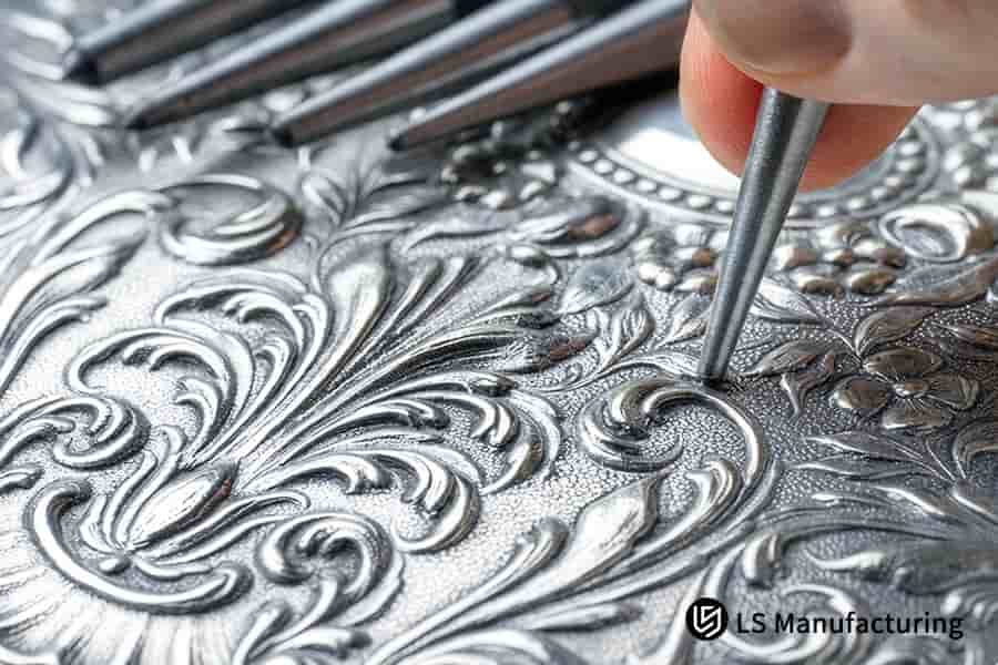 La goffratura a mano incide motivi intricati su pannello decorativo argento con una profondità di rilievo di 0,3 mm.