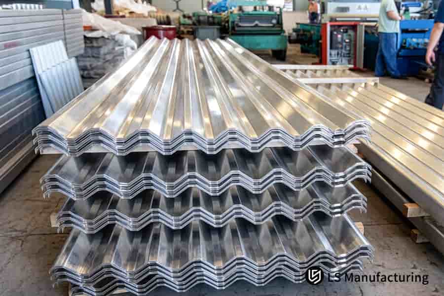 I pannelli del tetto in alluminio impilati attendono l'operazione di profilatura nel magazzino della fabbrica.