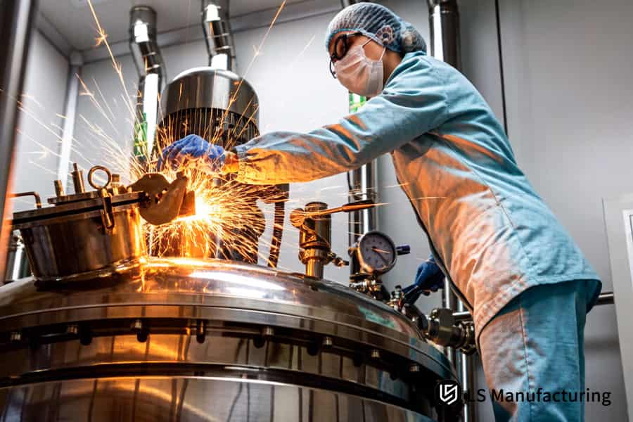 A technician grinds 316L stainless steel clamp edges for an ISO 13485 certified sheet metal​ medical system.
