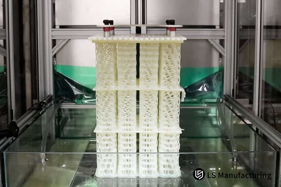 Un operario maneja el servicio de impresión 3D SLA para dar forma a una torre de moldes de resina blanca para joyería.